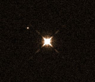 This image from the Hubble Space Telescope shows the star HAT-P-11 (center), which has a Neptune-size planet that is the smallest yet known to have water in its atmosphere. The planet, HAT-P-11b, is not visible in this image. The other bright object seen here is another star.