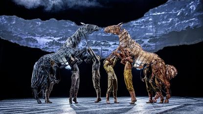 Puppet horses rise up towards each other on stage of War Horse at National Theatre, 2026