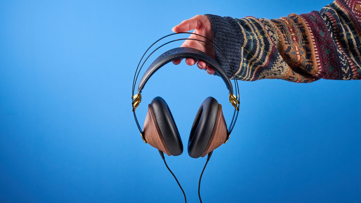 the meze 99 classics 2nd gen headphones with walnut finishes and gold touches against the blue tom's guide background