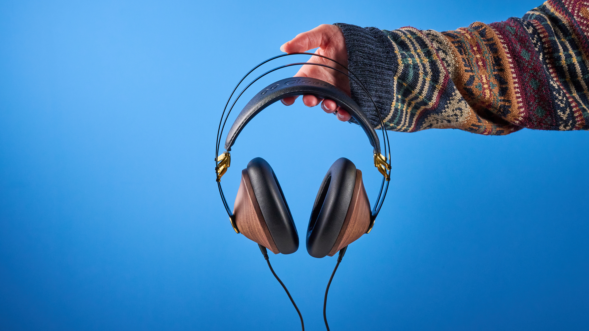 the meze 99 classics 2nd gen headphones with walnut finishes and gold touches against the blue tom&#039;s guide background
