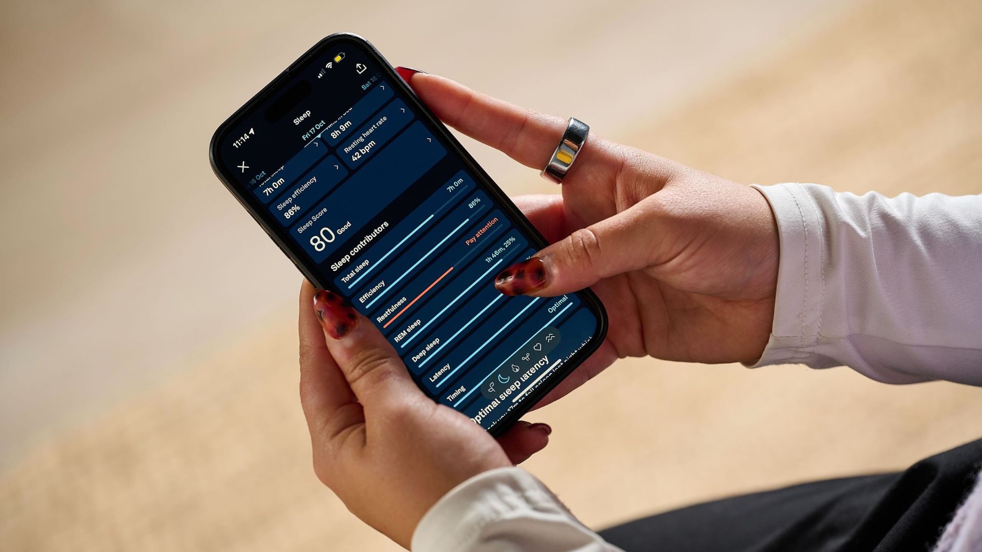 Tom's Guide's sleep tech tester checking sleep data from the silver Oura Ring 4 via Oura App on mobile phone 