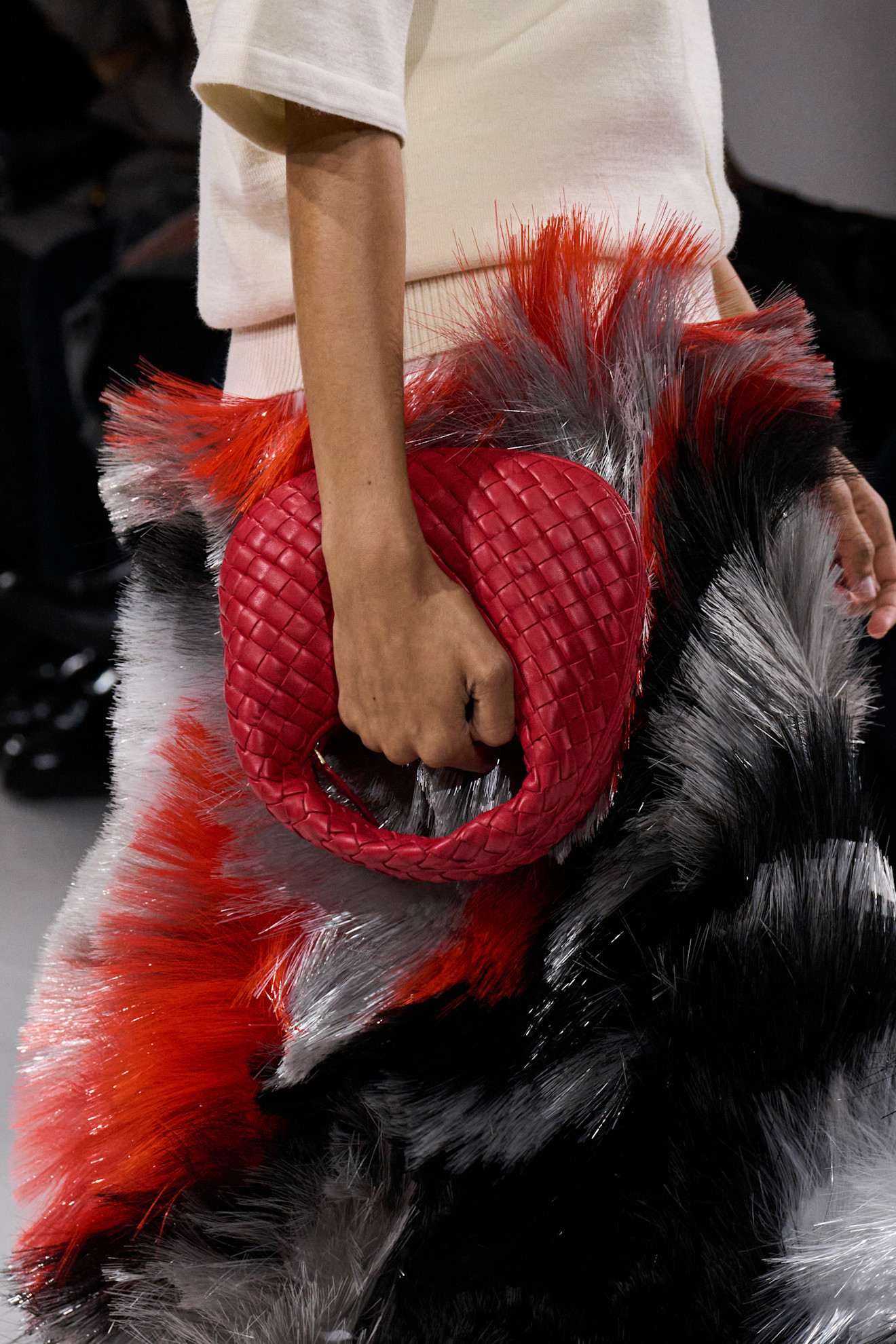 Model carries veneta Bottega Veneta bag in red