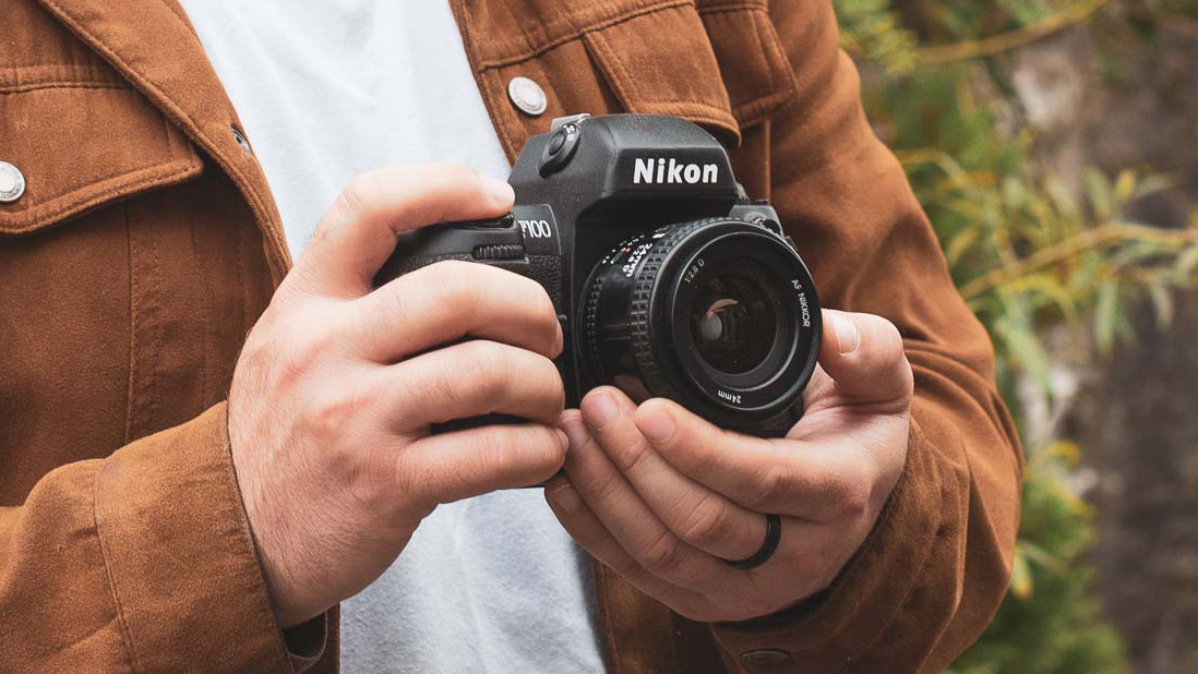 Two hands holding a retro film camera