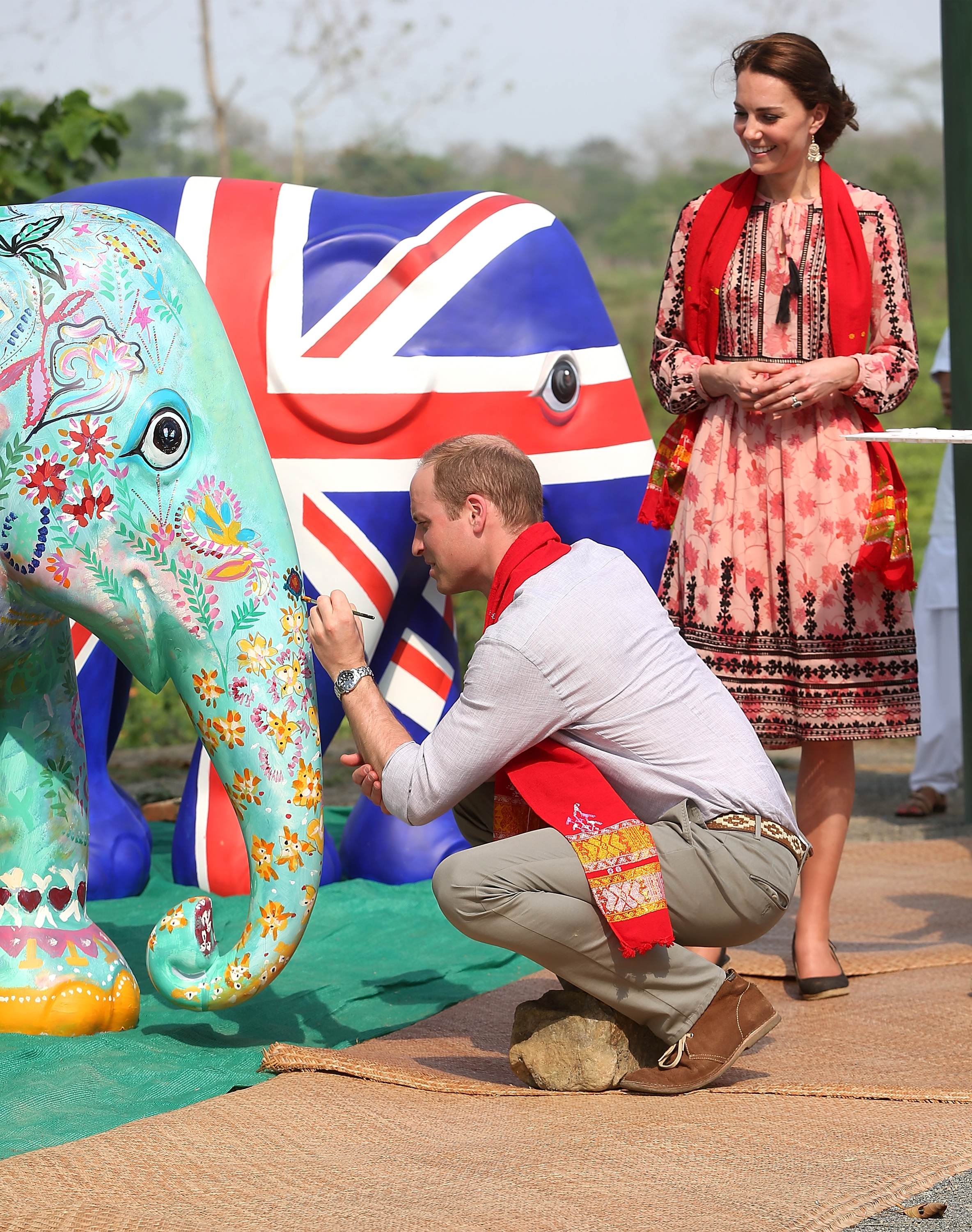 Prince William painting an elephant as Princess Kate watches on