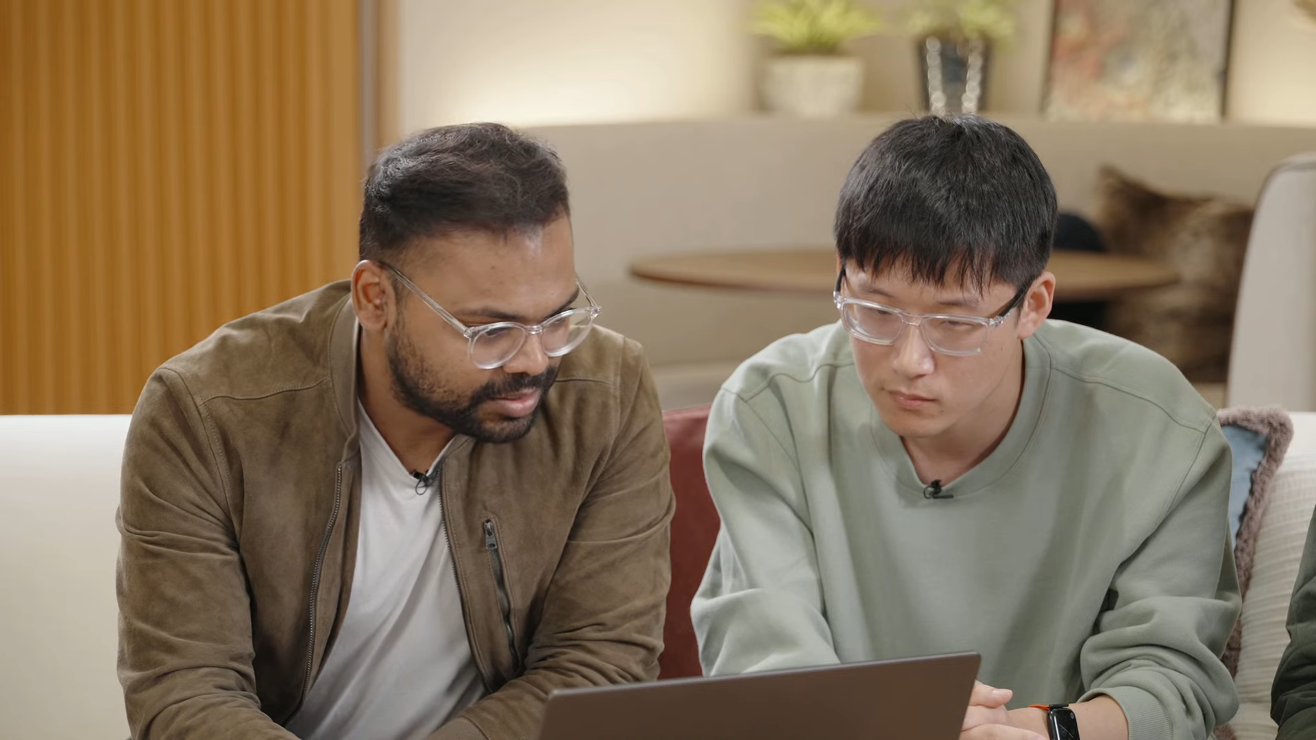 Two OpenAI engineers looking at a laptop
