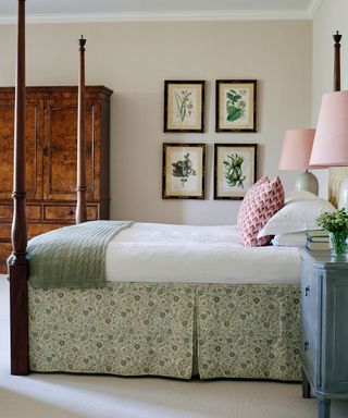 An example of guest bedroom ideas showing a four poster bed with green and white bedding and pictures on the wall