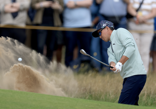 Rickie Fowler plays a bunker shot during The Open