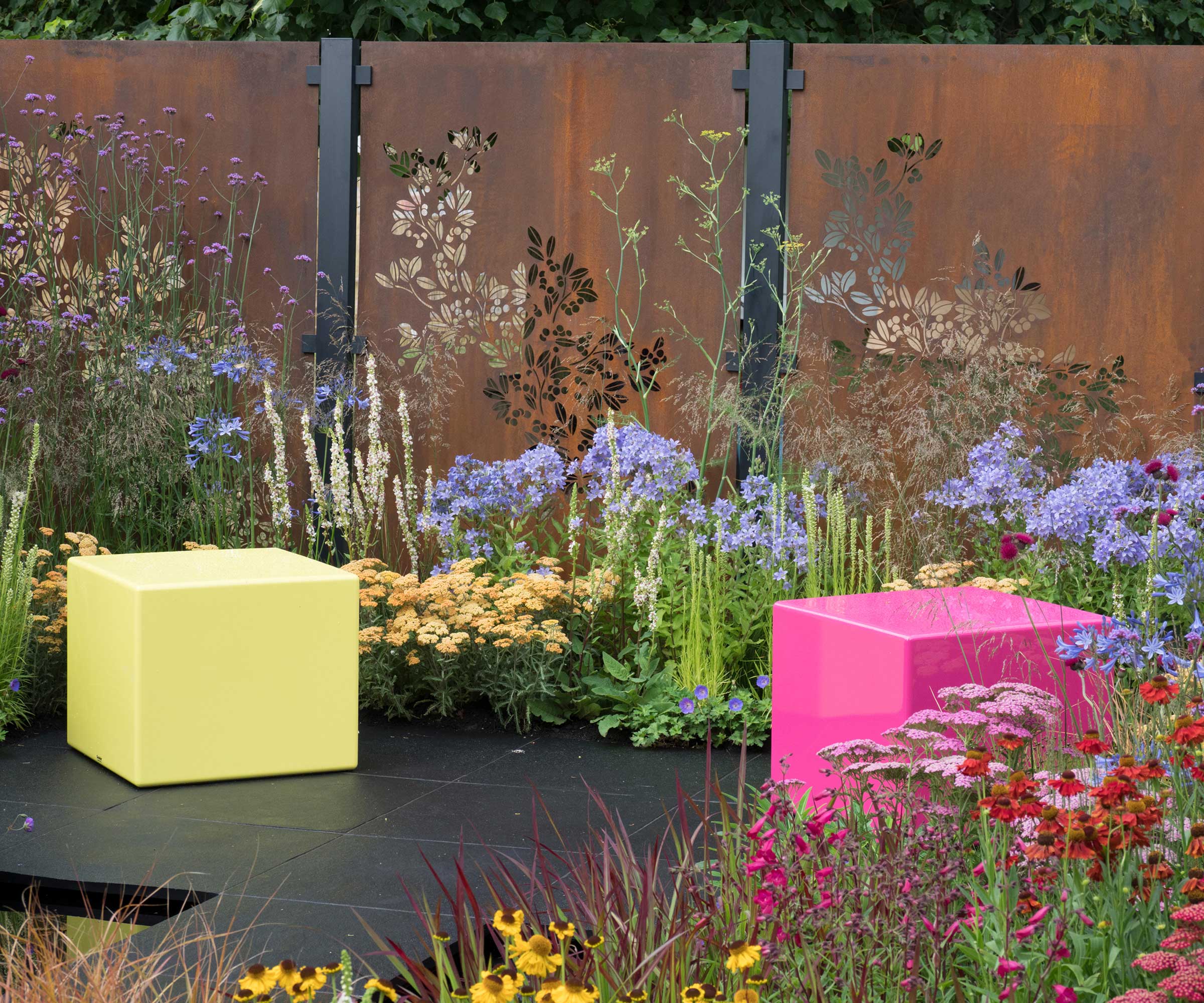 The Colour Box Show Garden Designed by Charlie Bloom and Simon Webster with weathering steel panels and colorful flowers