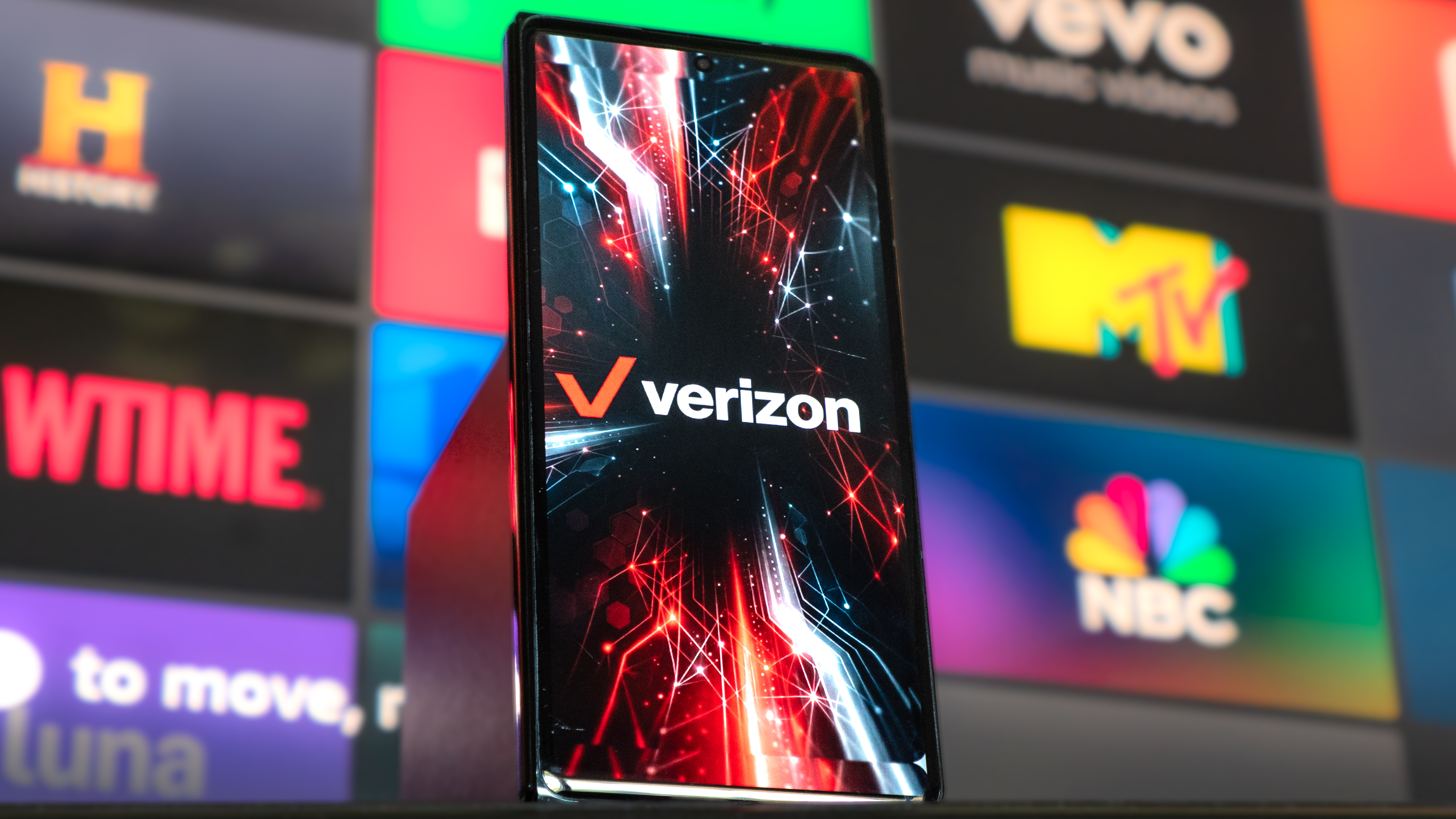 تلفن با آرم Verizon Wireless روی صفحه در دست گرفته شده است.