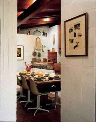 The white walls contrast with the dominant wood beams in the dining room