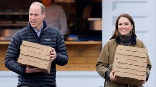 Prince William, Prince of Wales and Catherine, Princes of Wales carry takeaway pizza boxes