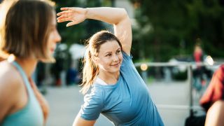 Woman performs a dynamic side stretch as a warm-up exercise