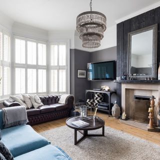grey living room with fireplace, large window and two sofas