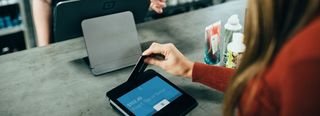 Woman using a point of sale card reader as part of Integrated POS Systems setup