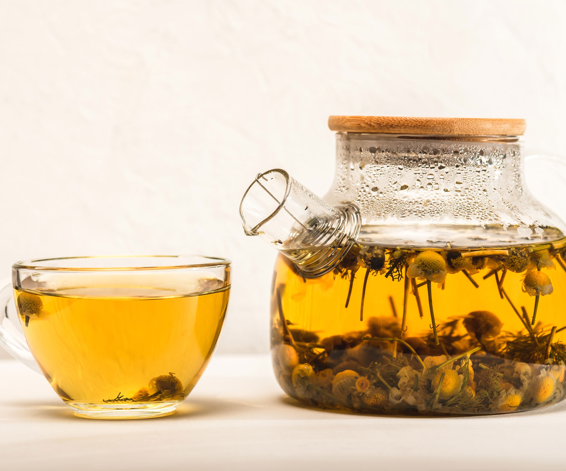 chamomile tea in glass cup and glass teapot