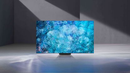 Samsung Neo QLED TV with rippling blue pattern on, in a grey room