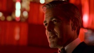 George Clooney standing in front of a lot of red lights in Ocean's Thirteen.