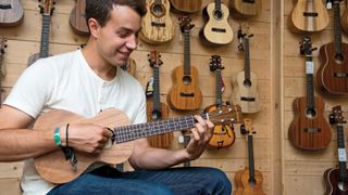Man playing ukulele in a guitar store
