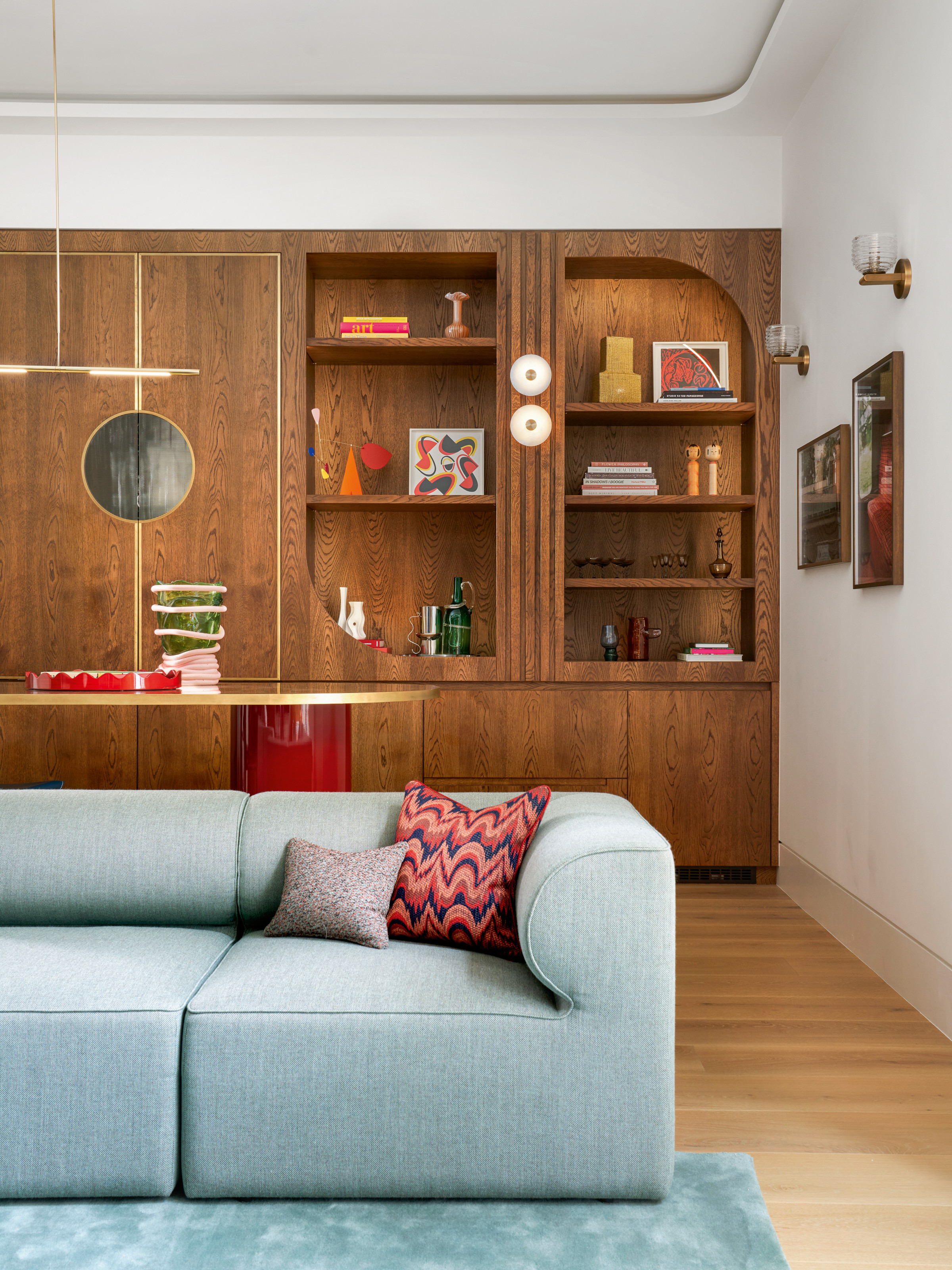 Art Deco-style built-in joinery with arched details, with light blue sofa in front