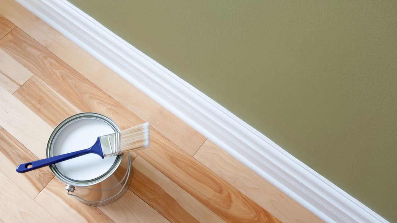 A tin of white paint next to a white trim