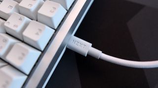 NZXT Function Elite MiniTKL with RGB lighting enabled on a desk.