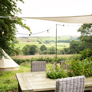 Garden with an outdoor table covered by a shade sail