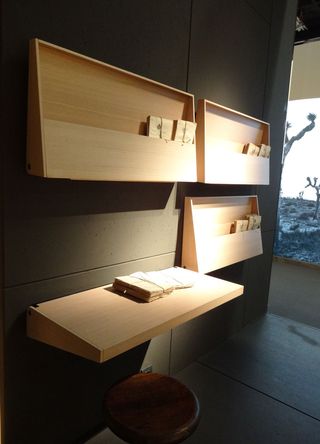 Wooden installation foldable desks on a wall