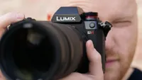 The Panasonic S1R being held up to a man's eye during testing
