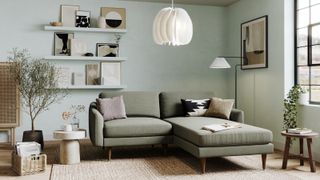 living room with soft green walls, large pale green sofa and wooden floor