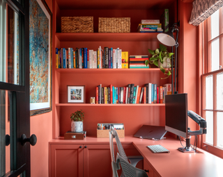 Warm pinky-red color drenched bookcase in office space