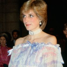 Princess Diana attends an event wearing a blue off the shoulder gown