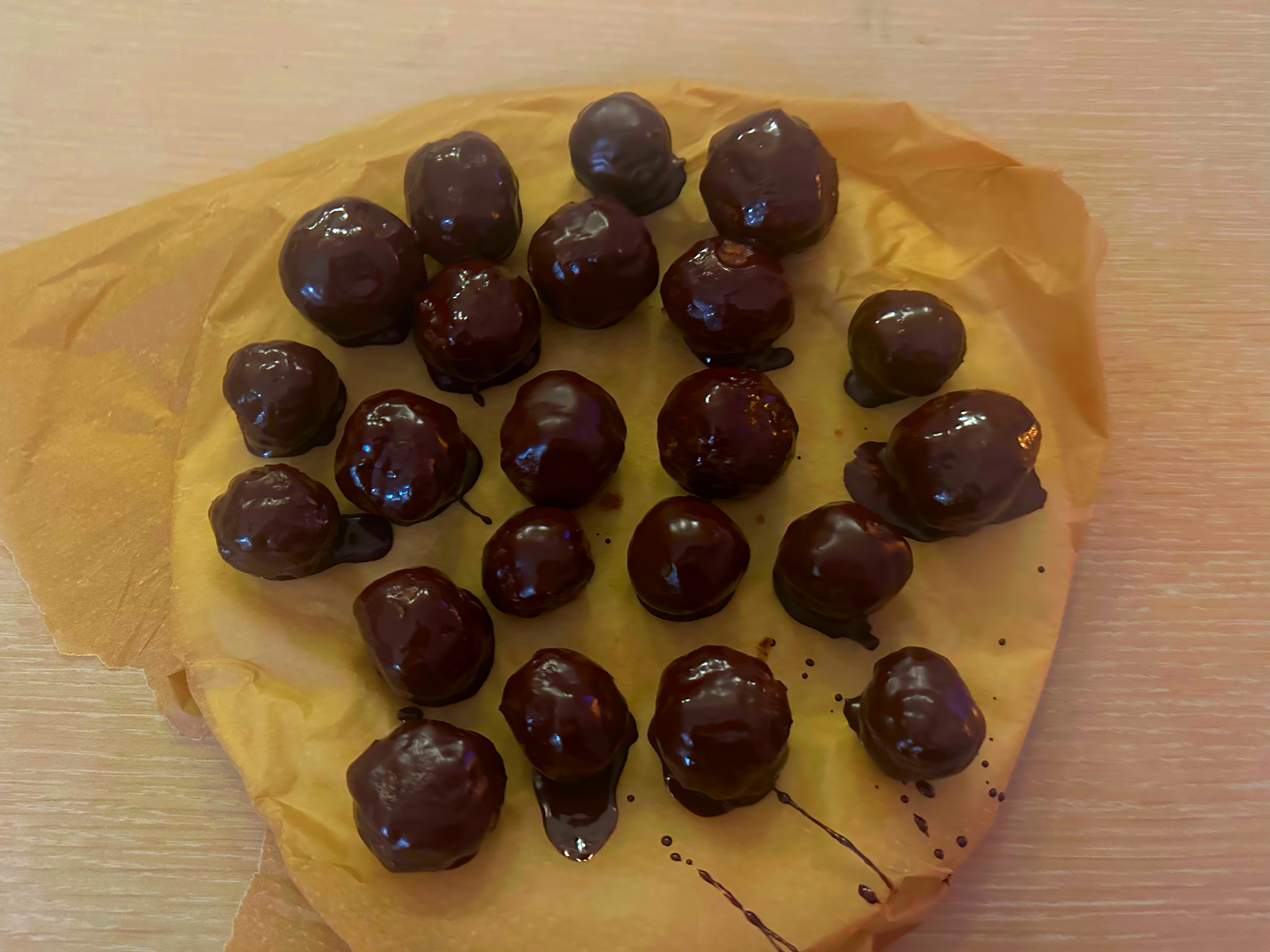 Chocolate-covered energy balls on a plate lined with baking paper