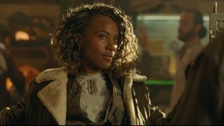 DeWanda Wise sits with a smile on her face in the underground dino market in Jurassic World Dominion.