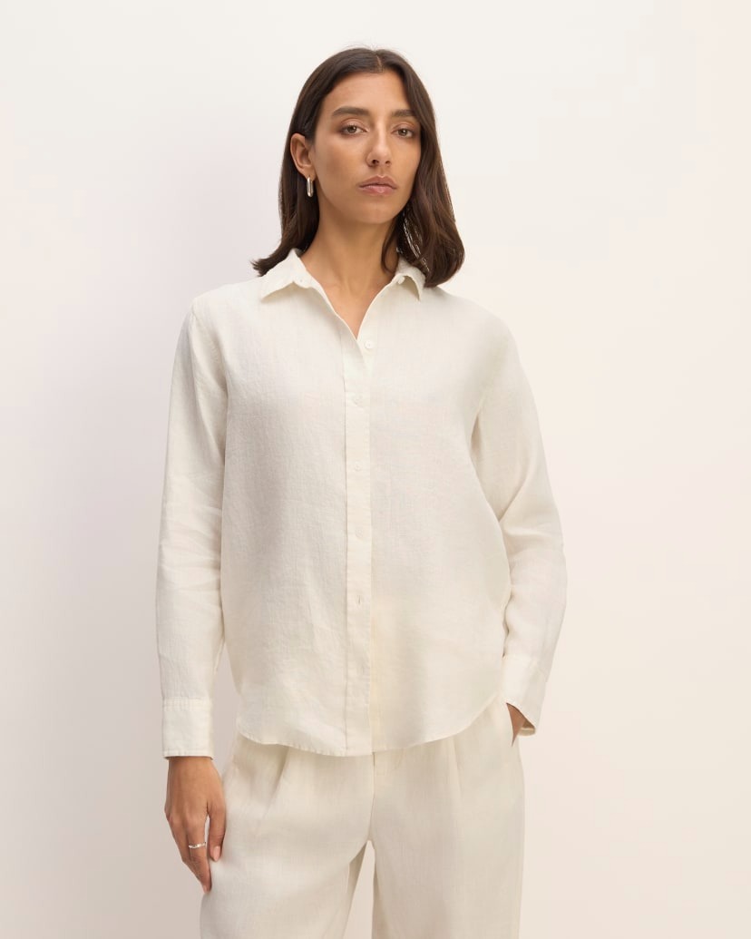 a model wears a white button-down collared shirt with matching pants