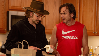 Bradley Cooper talks to Will Arnett in a kitchen