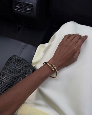 Sophisticated Fashion Trends: @sylviemus_ wears a simple gold bangle with a cream silk skirt