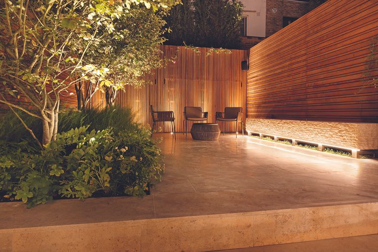 How to position landscape lighting in a modern garden with concrete patio and bamboo screen walls