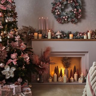 fireplace filled with candles and tree surrounded by presents