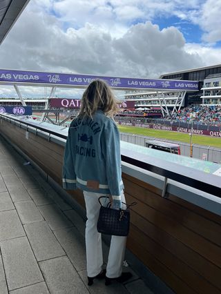 Eliza Huber wearing a denim Levi's x McLaren jacket with white Levi's 501 jeans and a brown Bottega Veneta bag at the British Grand Prix.