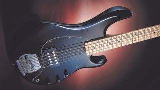 Sterling by Music Man SUB Ray5 review: Black 5-string SUB Ray5 bass guitar on a pink/purple background