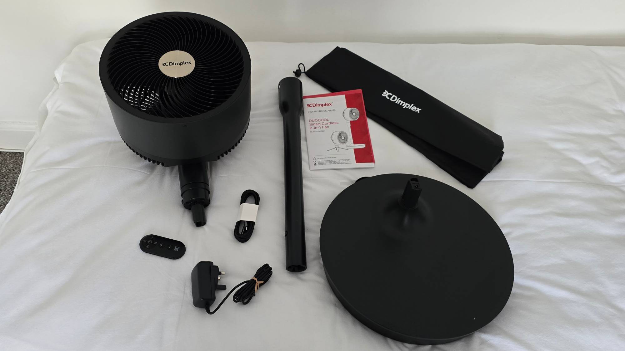 Dimplex DuoCool Smart Cordless 2-in-1 Fan laid out on bed