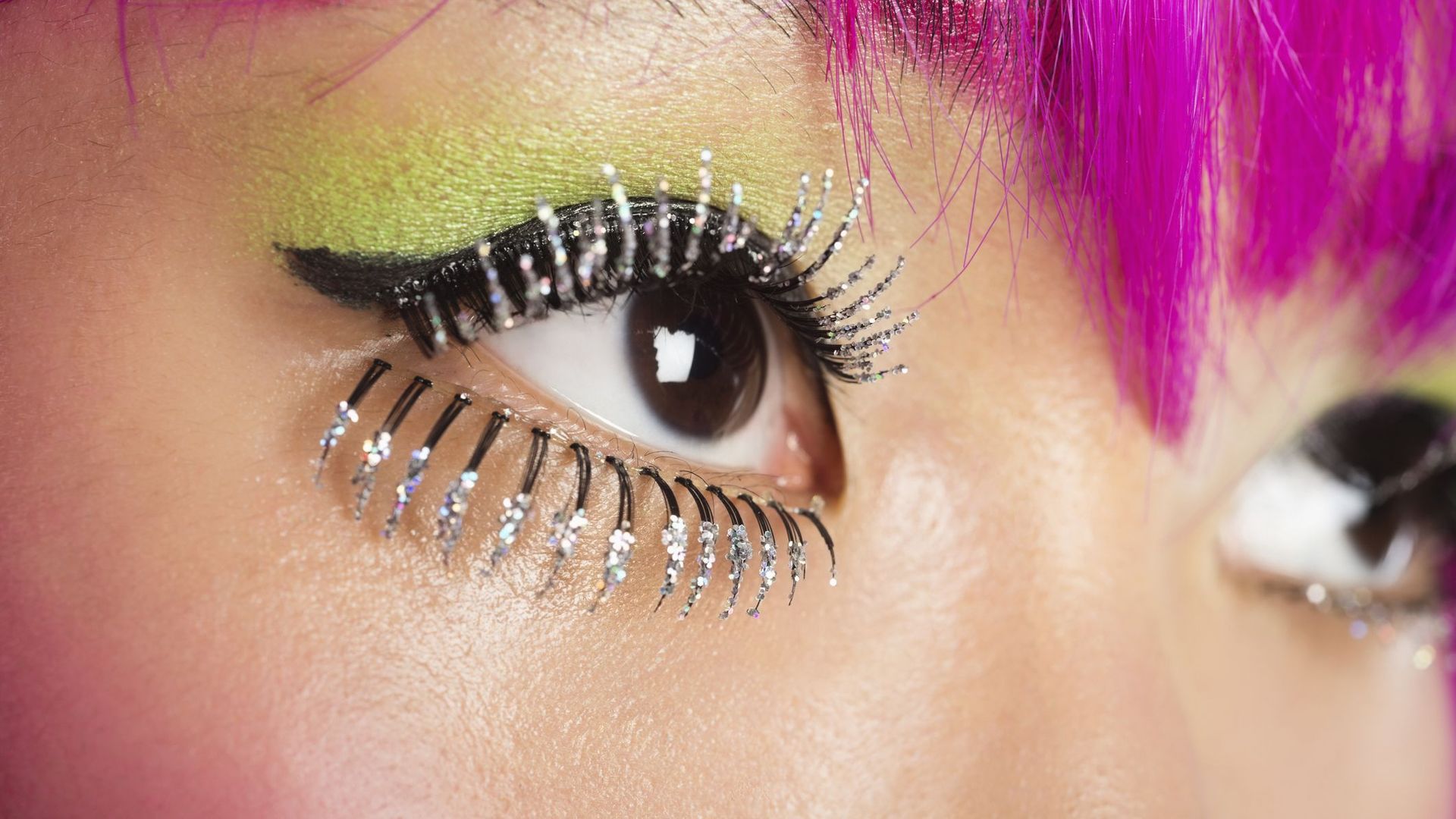 extreme close up of young funky woman's face with false eyelashes