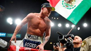 Canelo Alvarez feirer i ringen med et mexicansk flagg