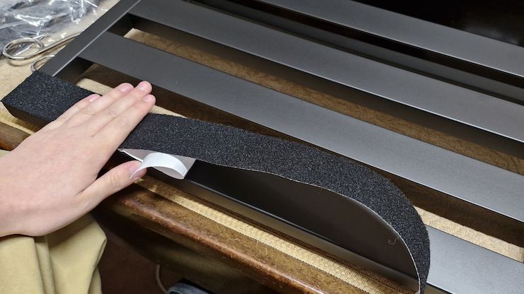 A man attaching Velcro to a Pedaltrain Classic 1 pedalboard