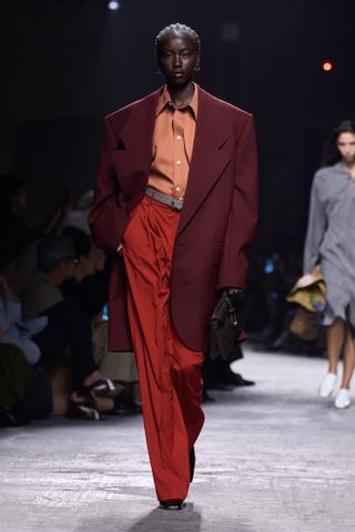 Spring Trouser Trends 2025: A model wears a pair of red trousers on the Bottega Veneta runway