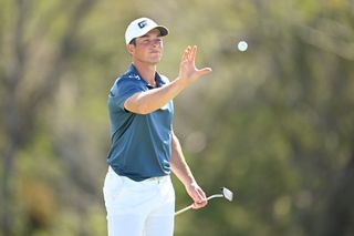 Viktor Hovland catches a golf ball