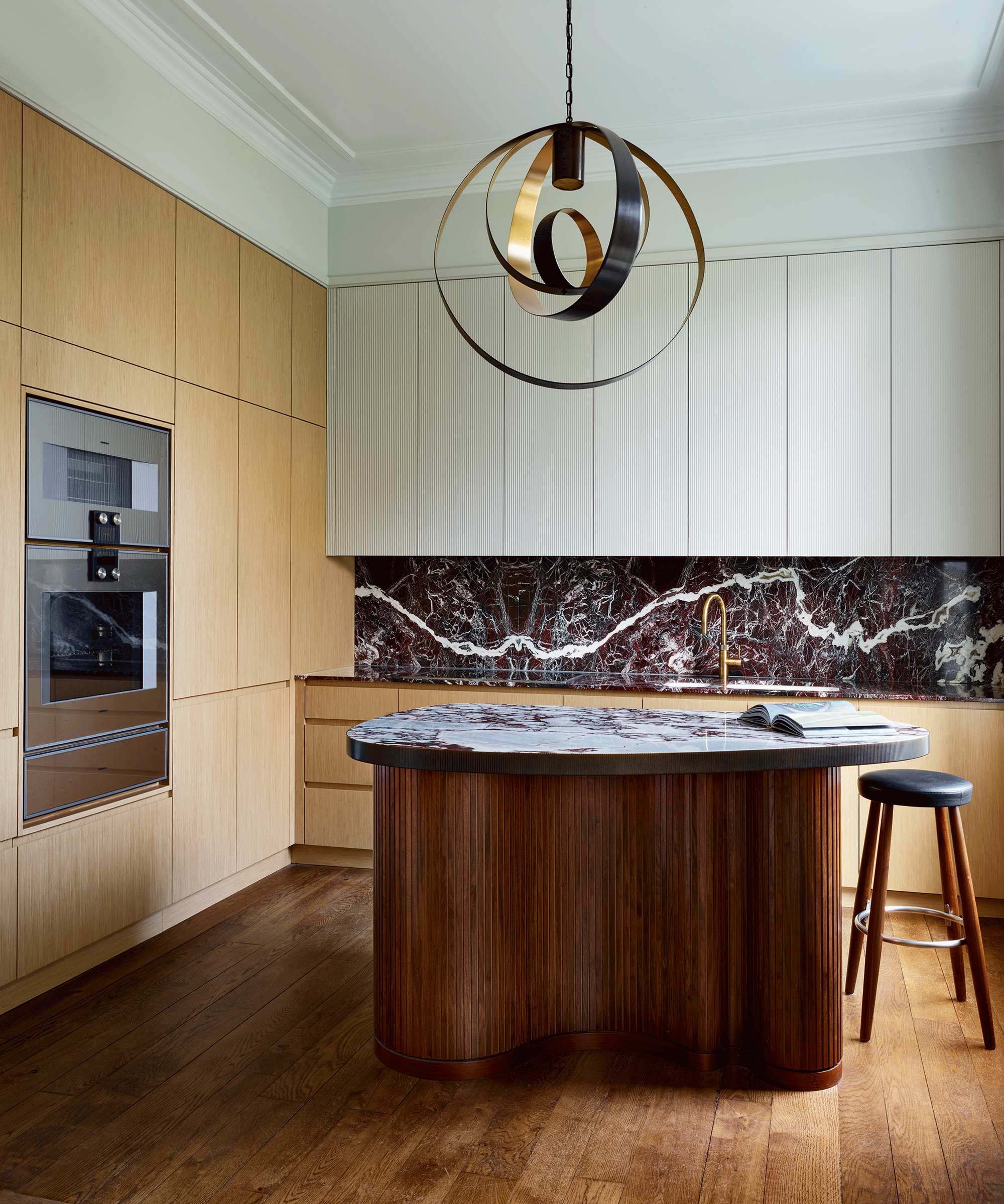 kitchen with solo statement pendant light over circular island