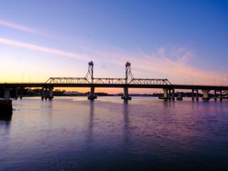 Bridge at sunrise across a river