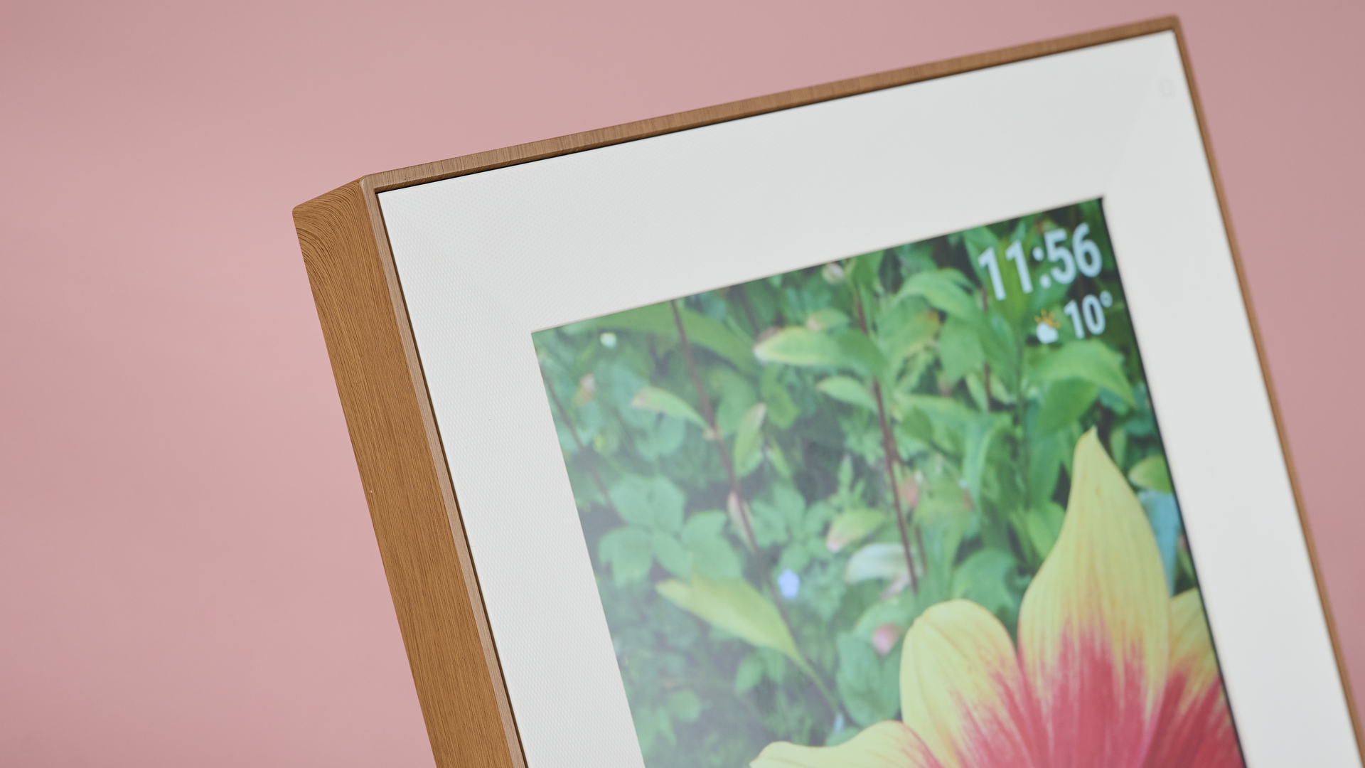 A closeup of the front of the Pexar Starlight 15.6-inch, showing the wood-grain frame and the local time and weather.