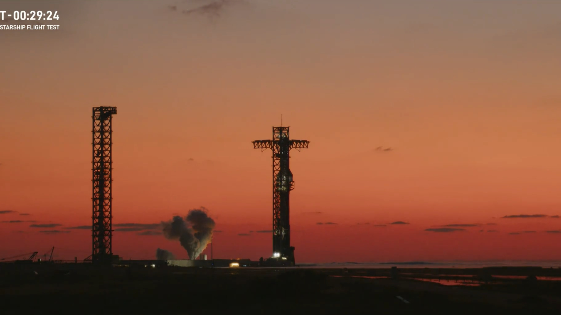 Een gigantische SpaceX Starship-raket op het lanceerplatform vlak voor zonsopgang met een gaspluim